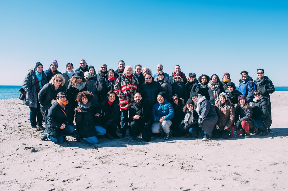 A large group of people pose for a picture on a beach