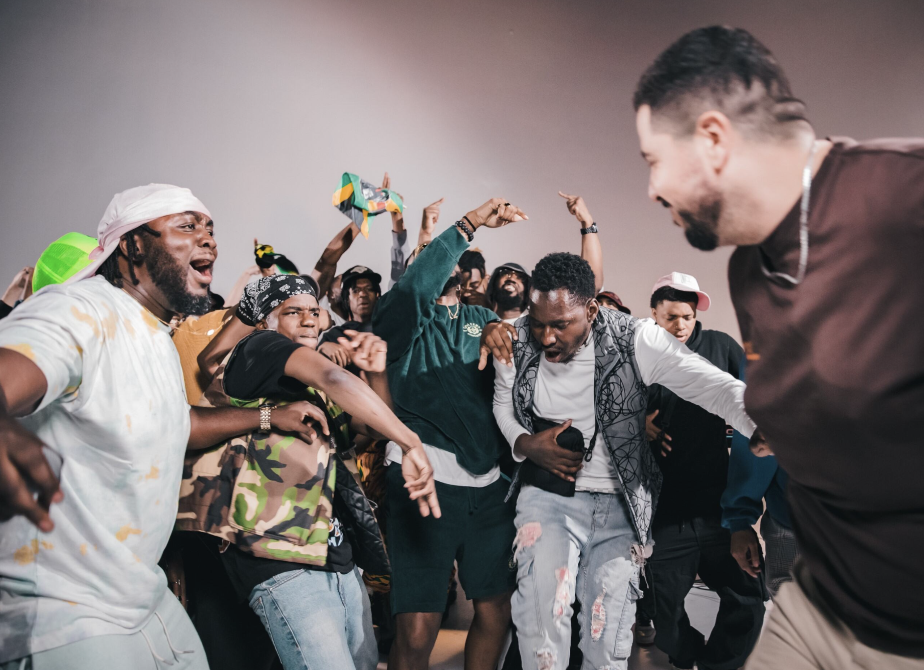 A group of people celebrate, jumping, shouting, hands in the air.